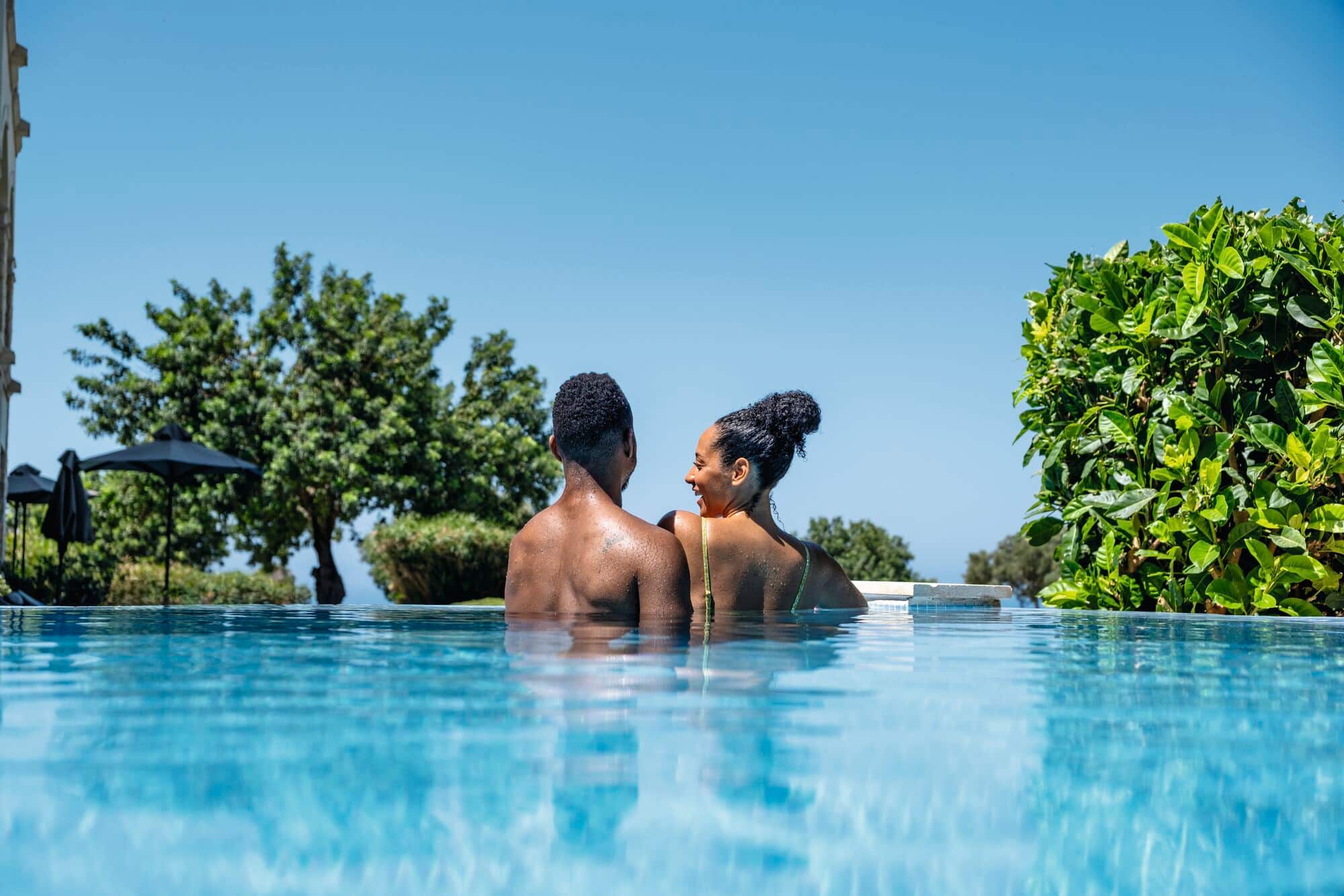 A couple relaxing in a swim-up room pool at the TUI BLUE Sensatori Atlantica Aphrodite Hills.