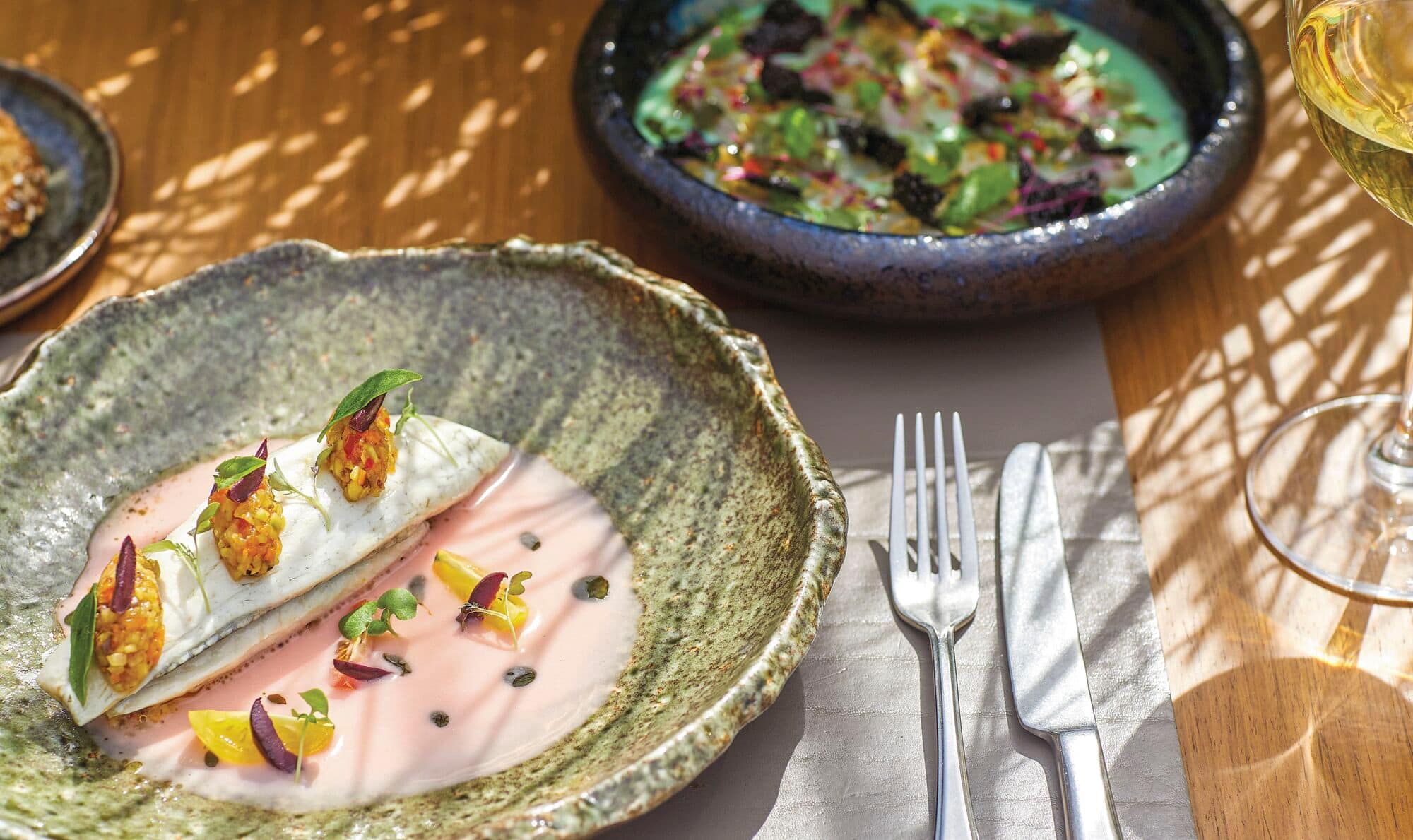 Two plates of food on a wooden table.