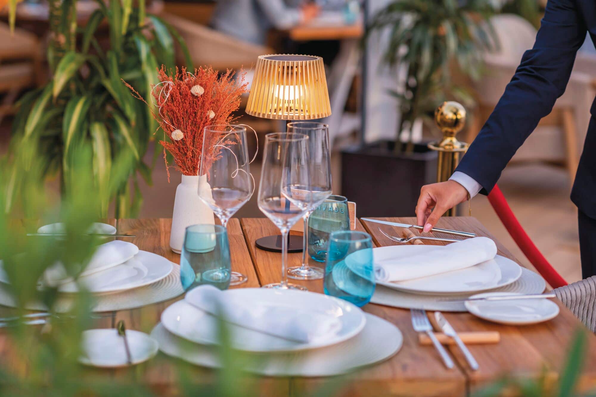 A table being set up for a fine dining experience.