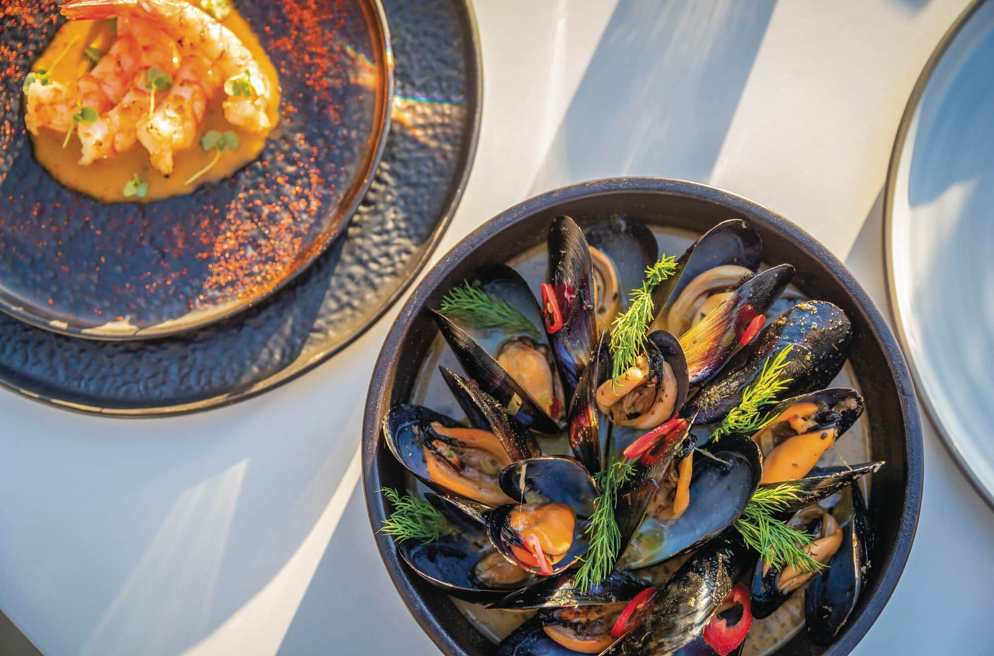 Muscles and prawns arranged neatly in bowls.