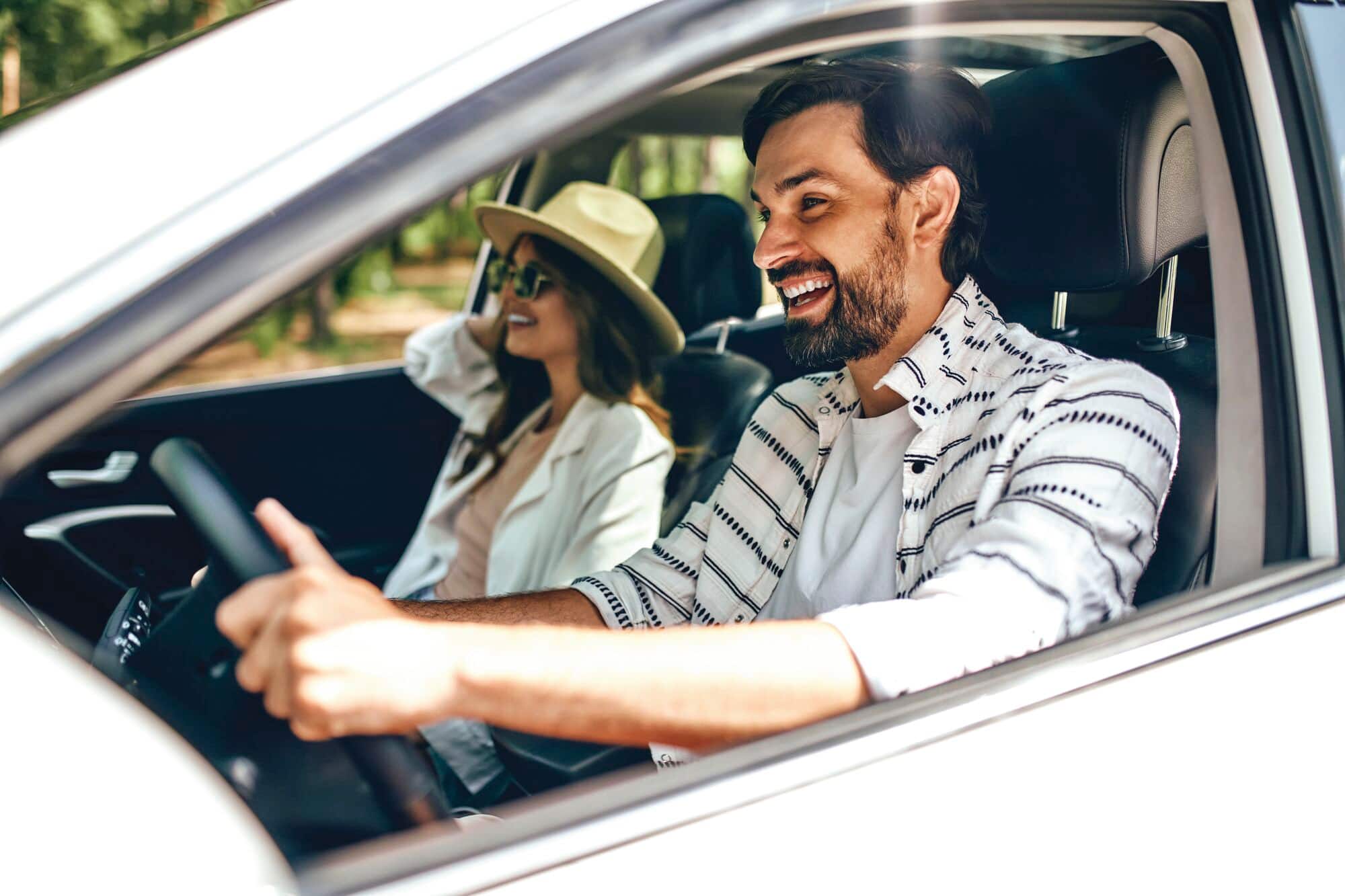 A smiling couple travelling in a car.