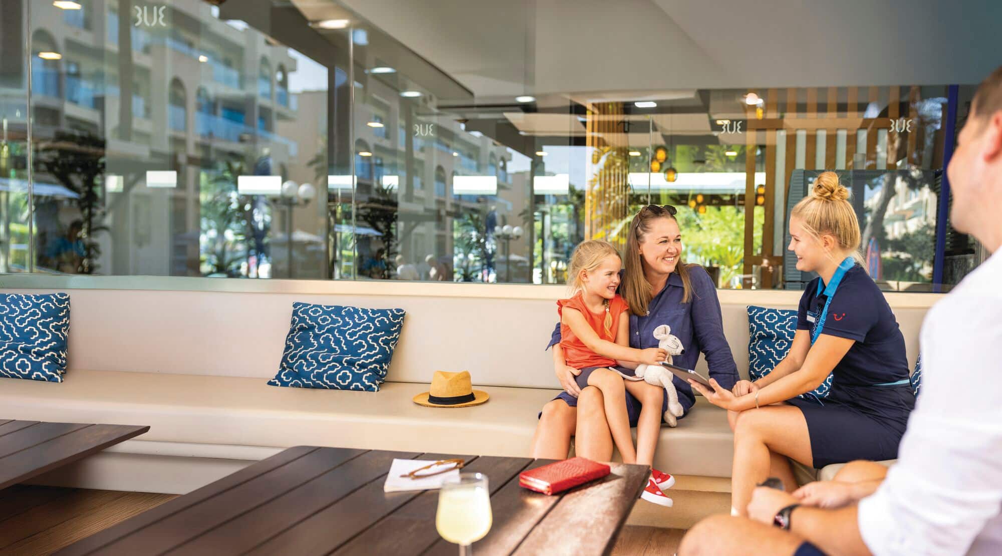 Resort staff welcoming guests in a bright, modern lobby seating area.