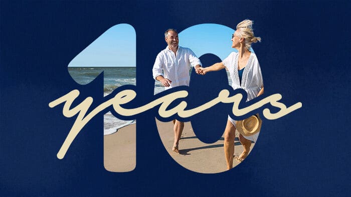 A couple holding hands on the beach behind an overlay that says "10 years".