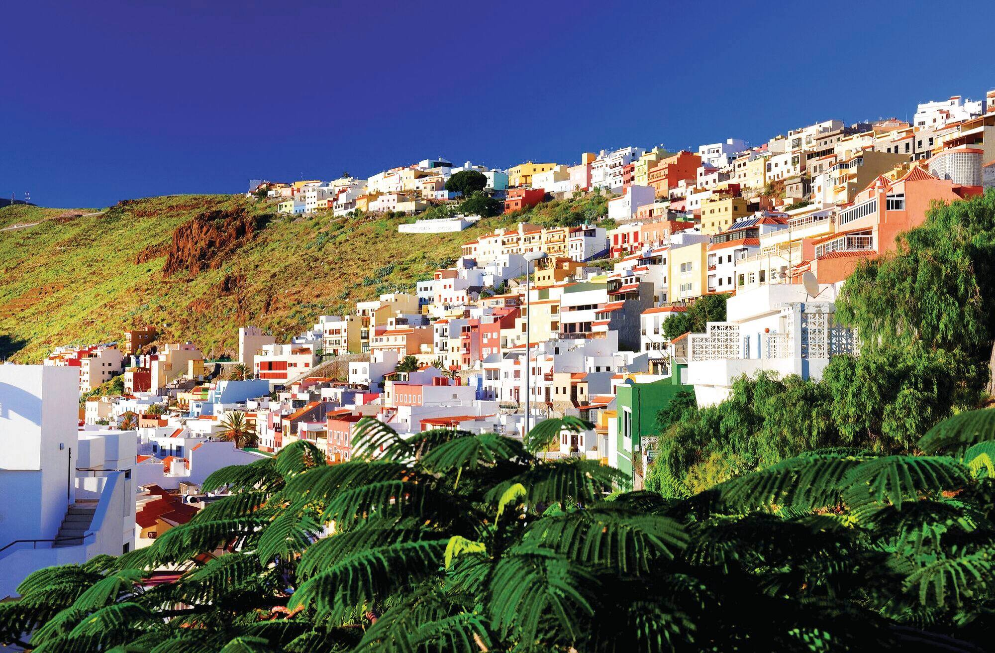 Colourful hillside town and lush green slopes.