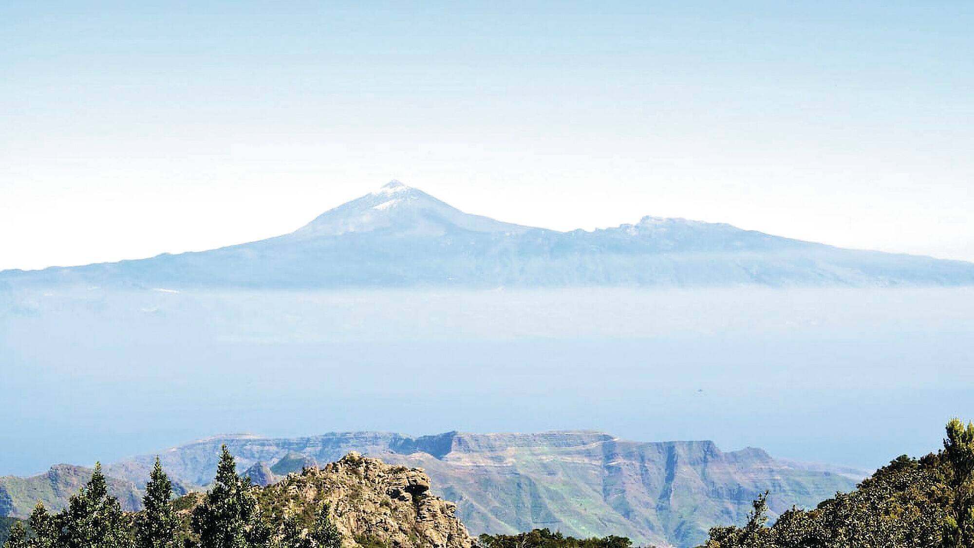 Distant mountain peak above a hazy horizon.