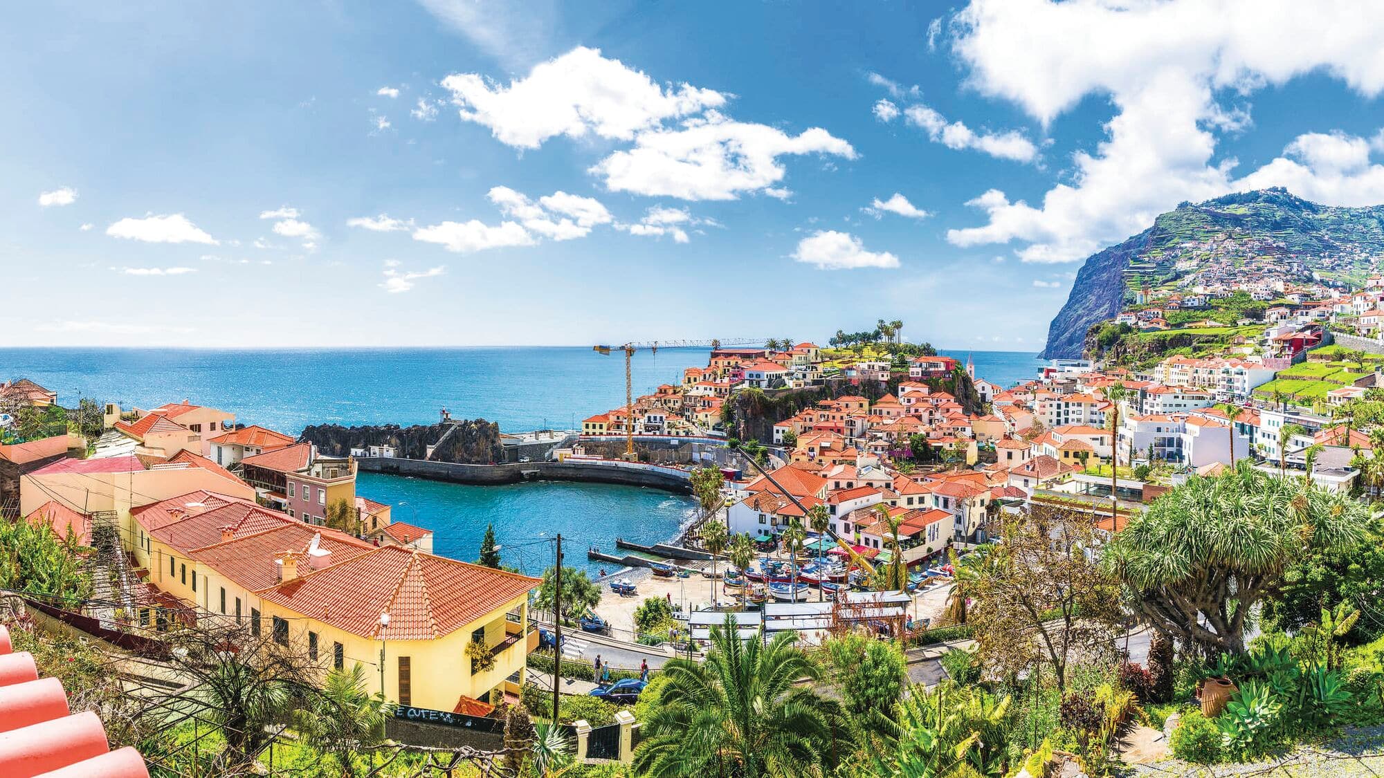 Coastal town with terracotta roofs beside the sea.