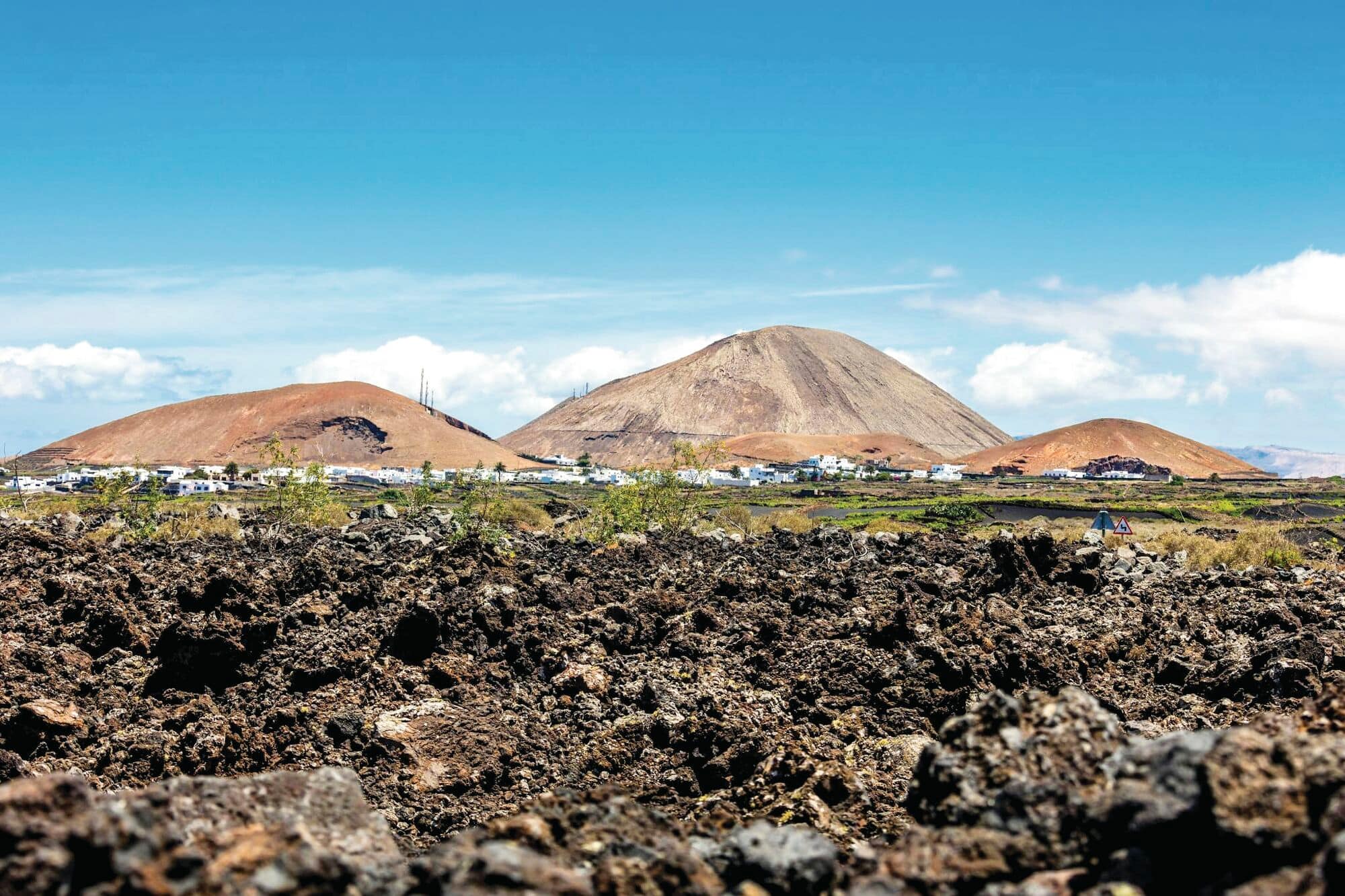 Volcanic hills behind a rocky lava field.