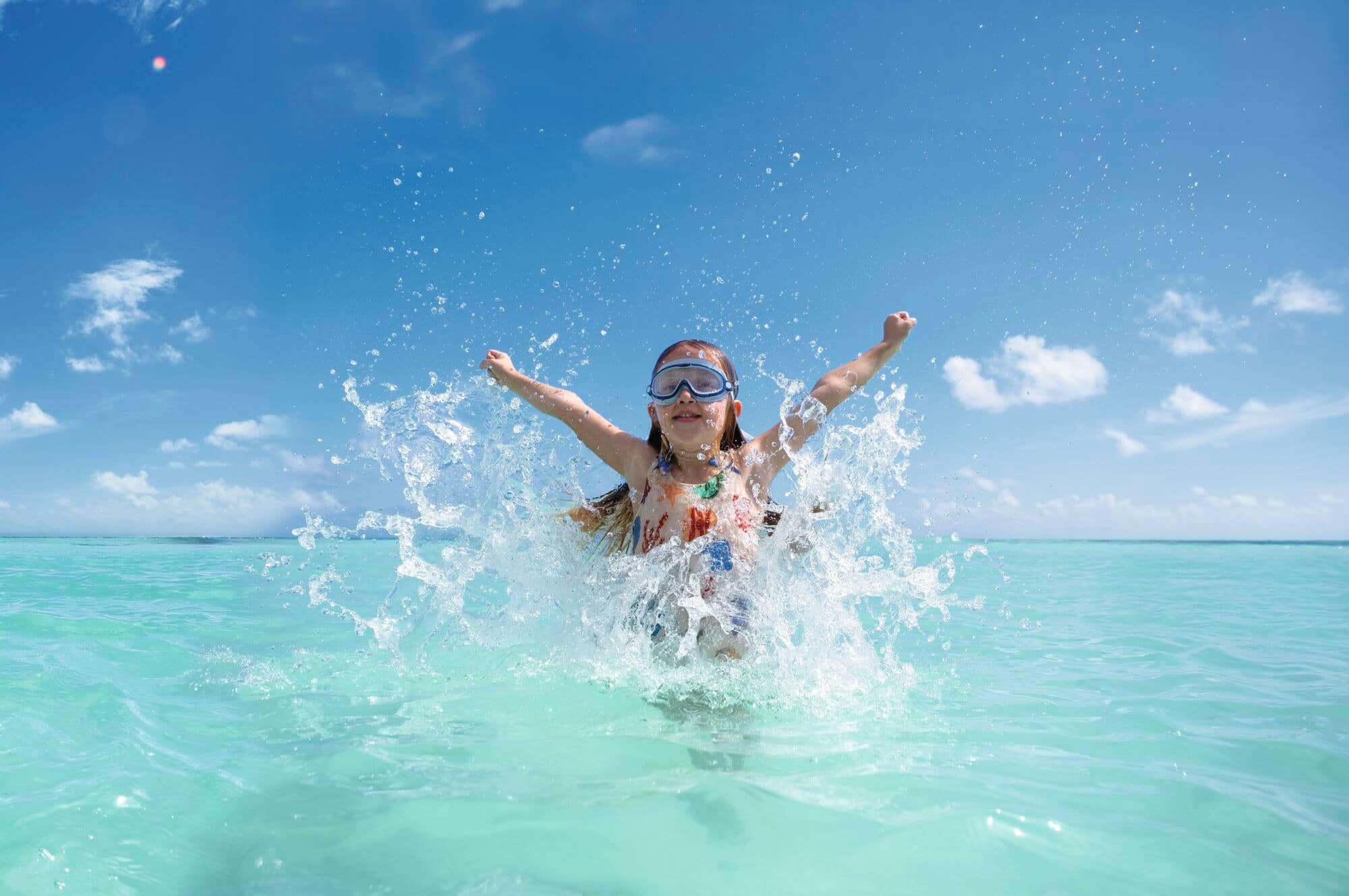 A little girl splashing around in the sea.
