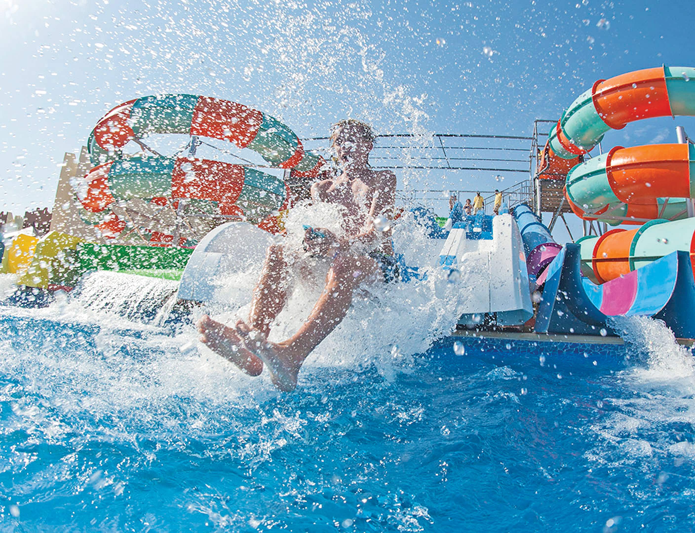 A child sliding down a colourful waterslide.