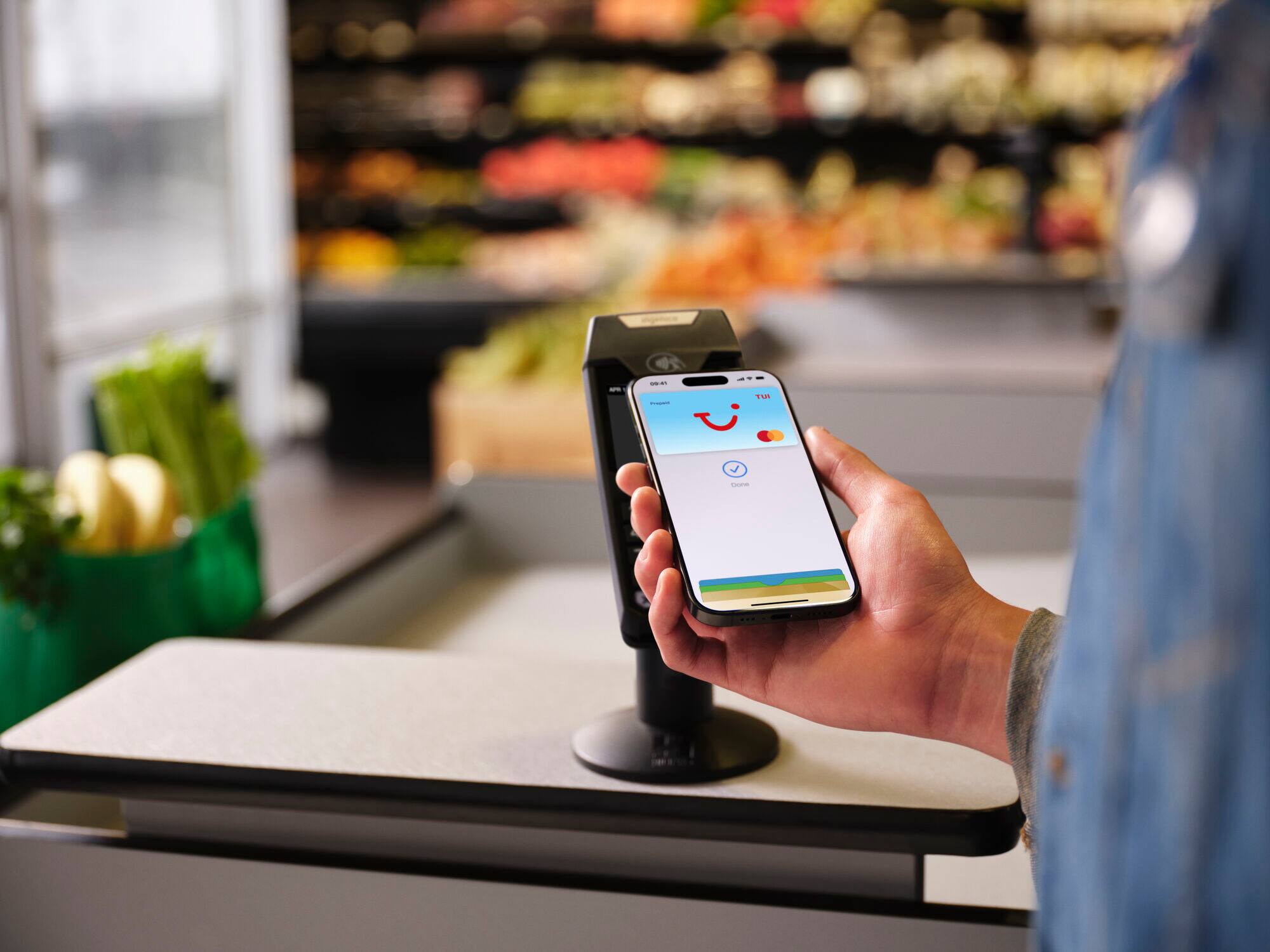 A person paying with Apple Pay at a card terminal.