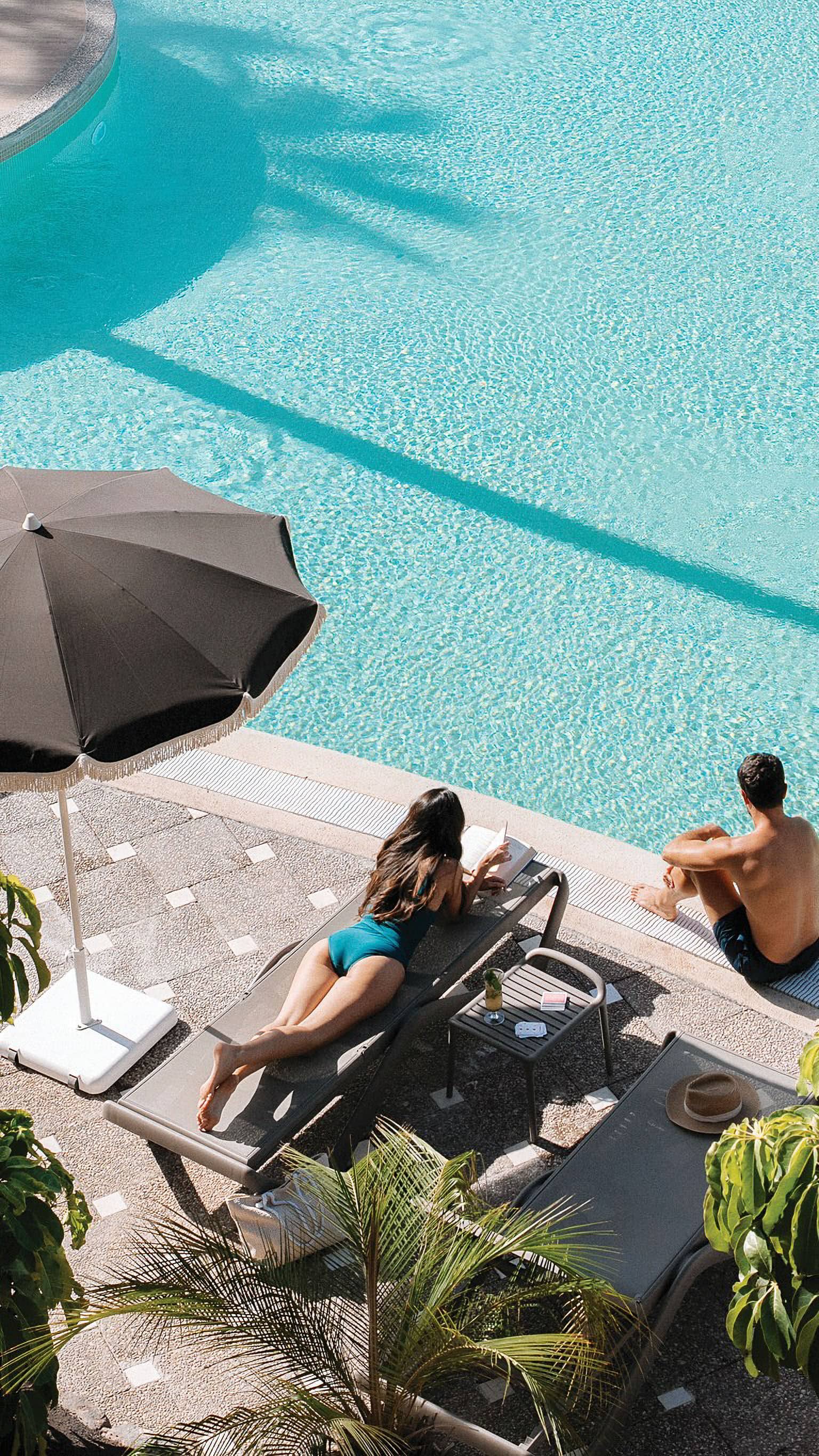 A couple relaxing by the pool.