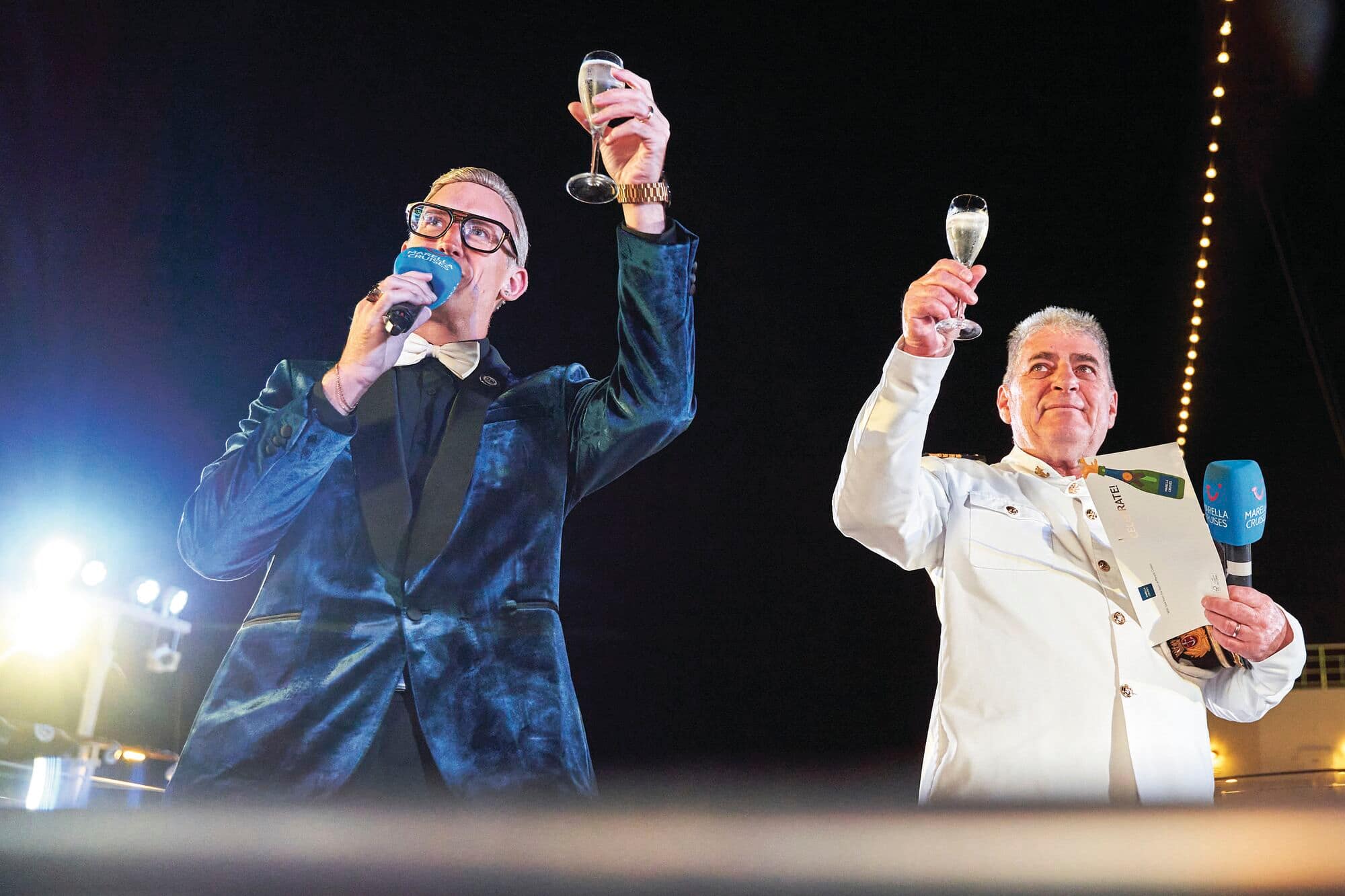 Two hosts toasting with champagne.