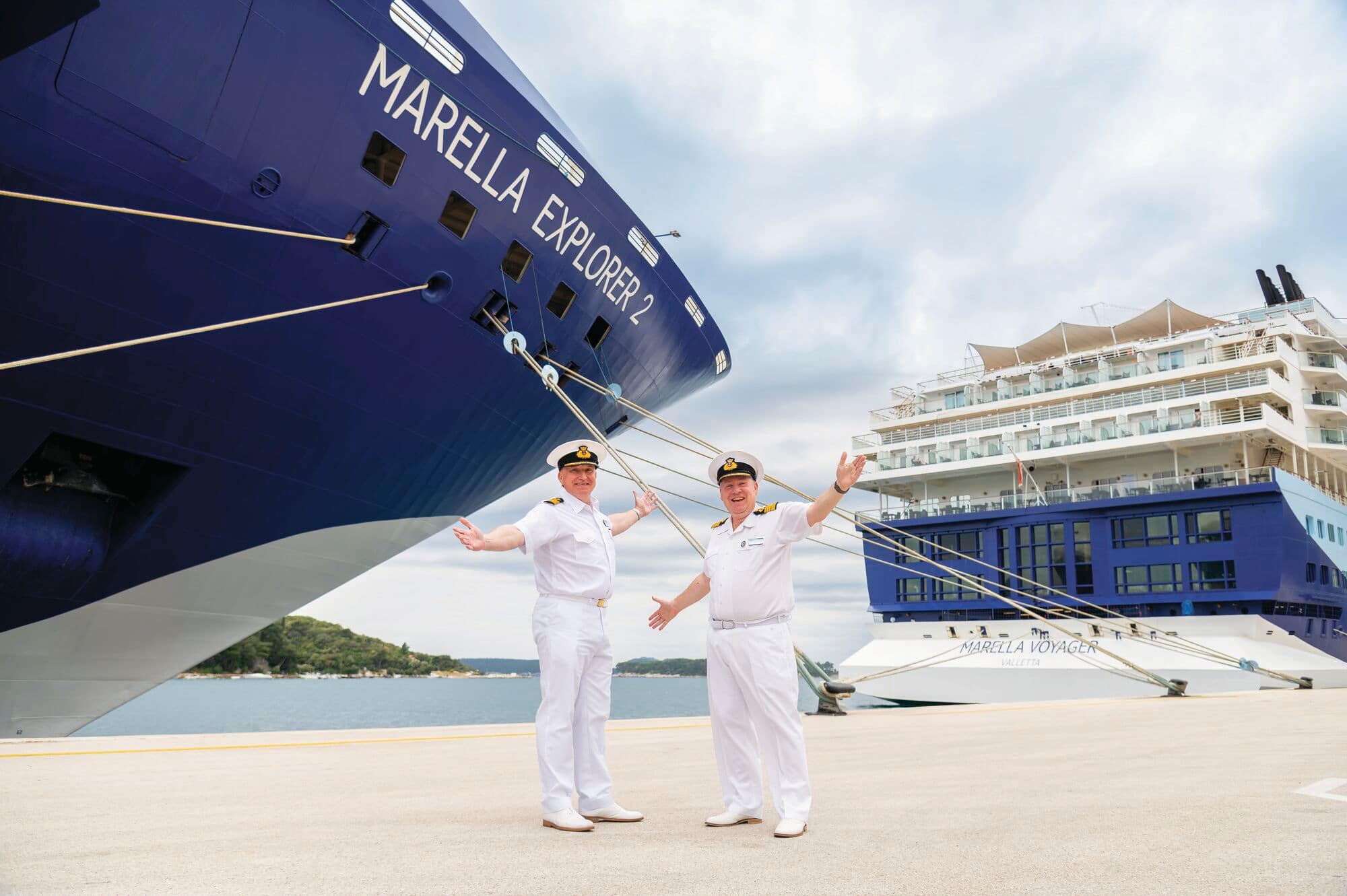 Ship captains posing for a photo in front of a Marella ship.