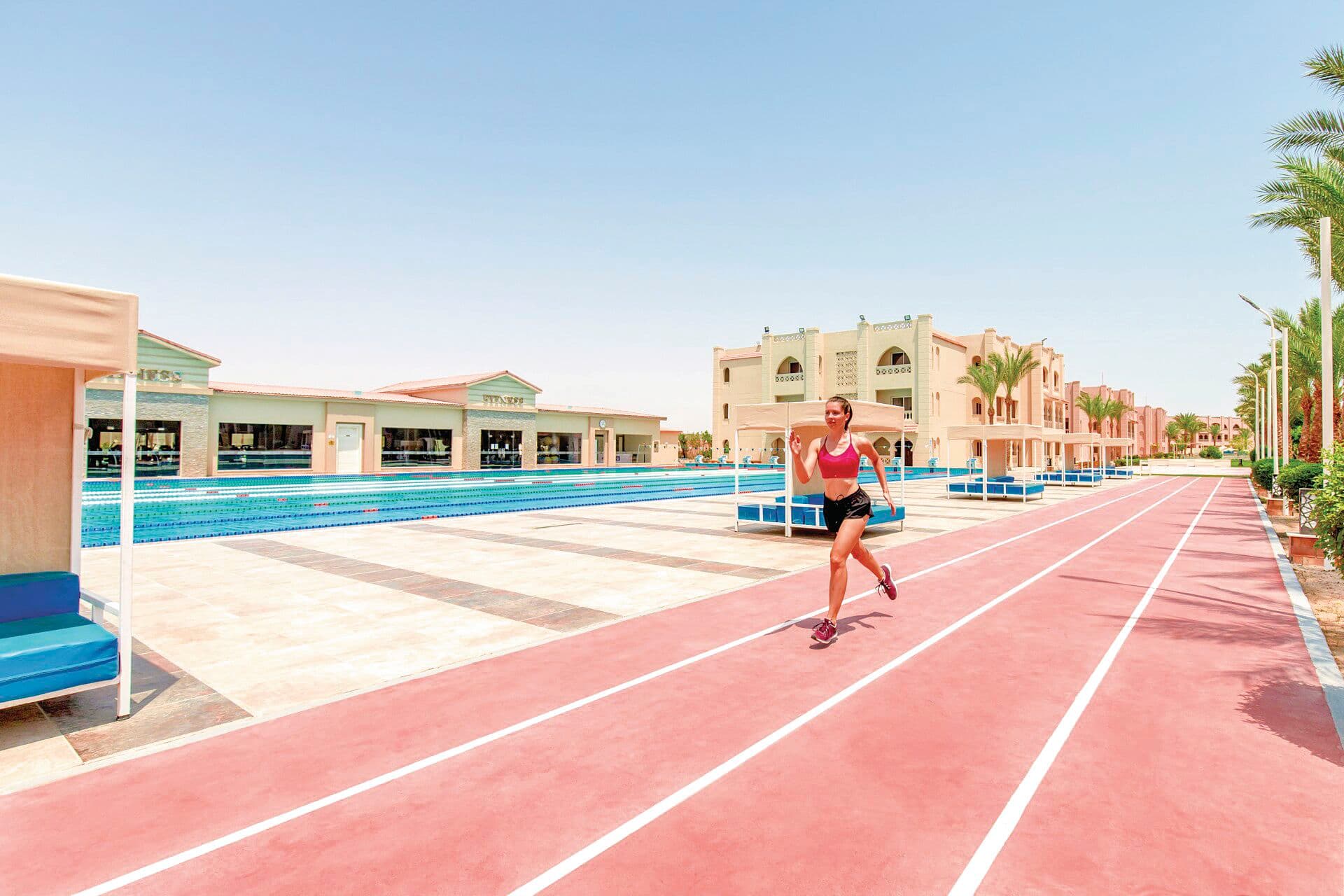A woman in sportswear running on a race track.