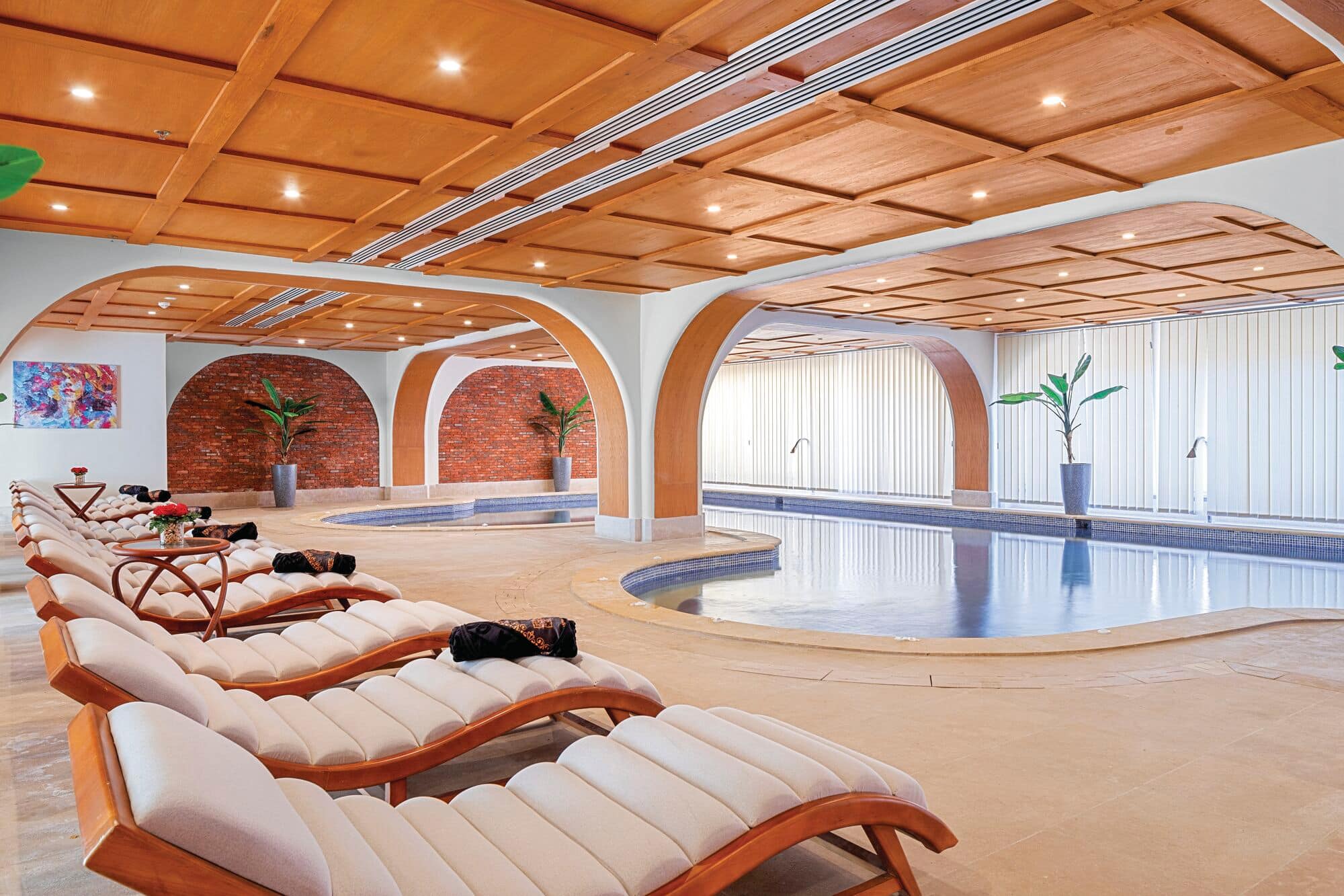 A row of sunloungers in front of a spa pool.