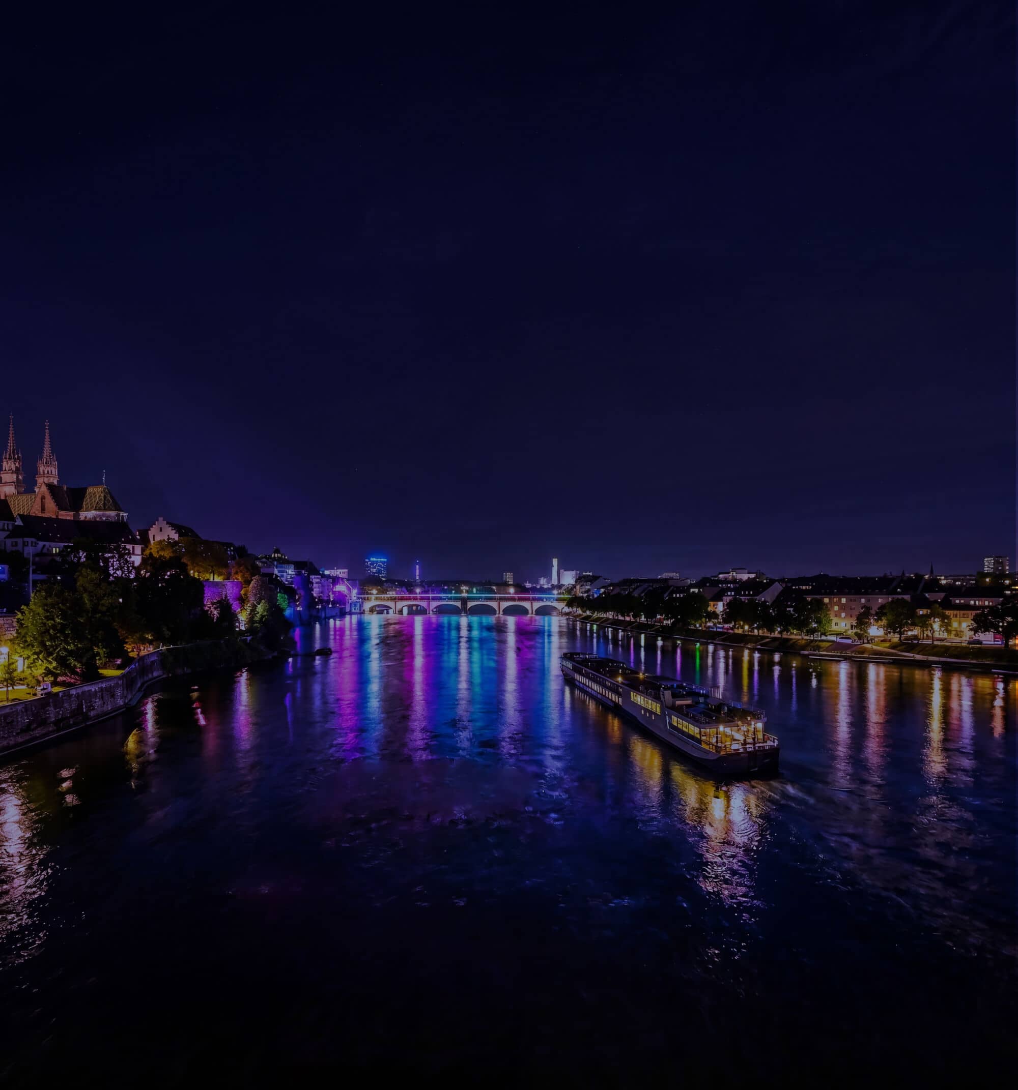 A river cruise ship on a river at night.