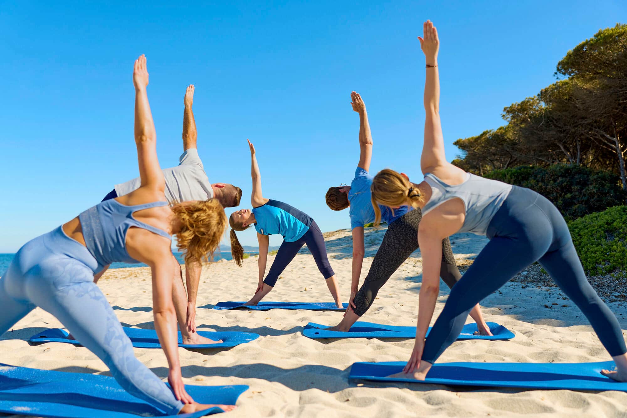 Guests taking part in a beach yoga session at TUI BLUE Matta Village in Sardinia.