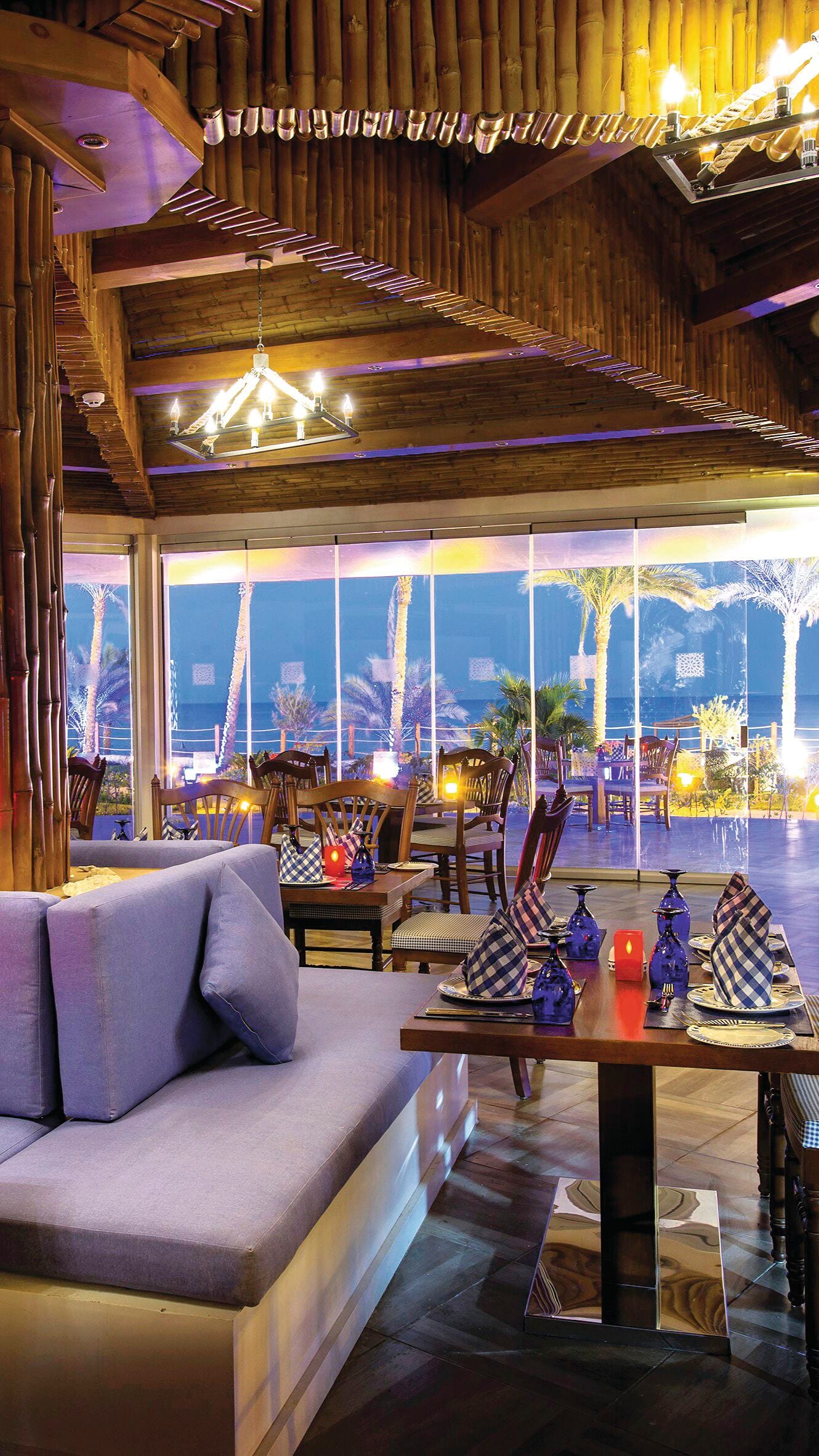 A comfy seating area at a restaurant with a sea view.
