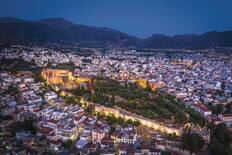 An aerial view of Patras, illuminated at dusk