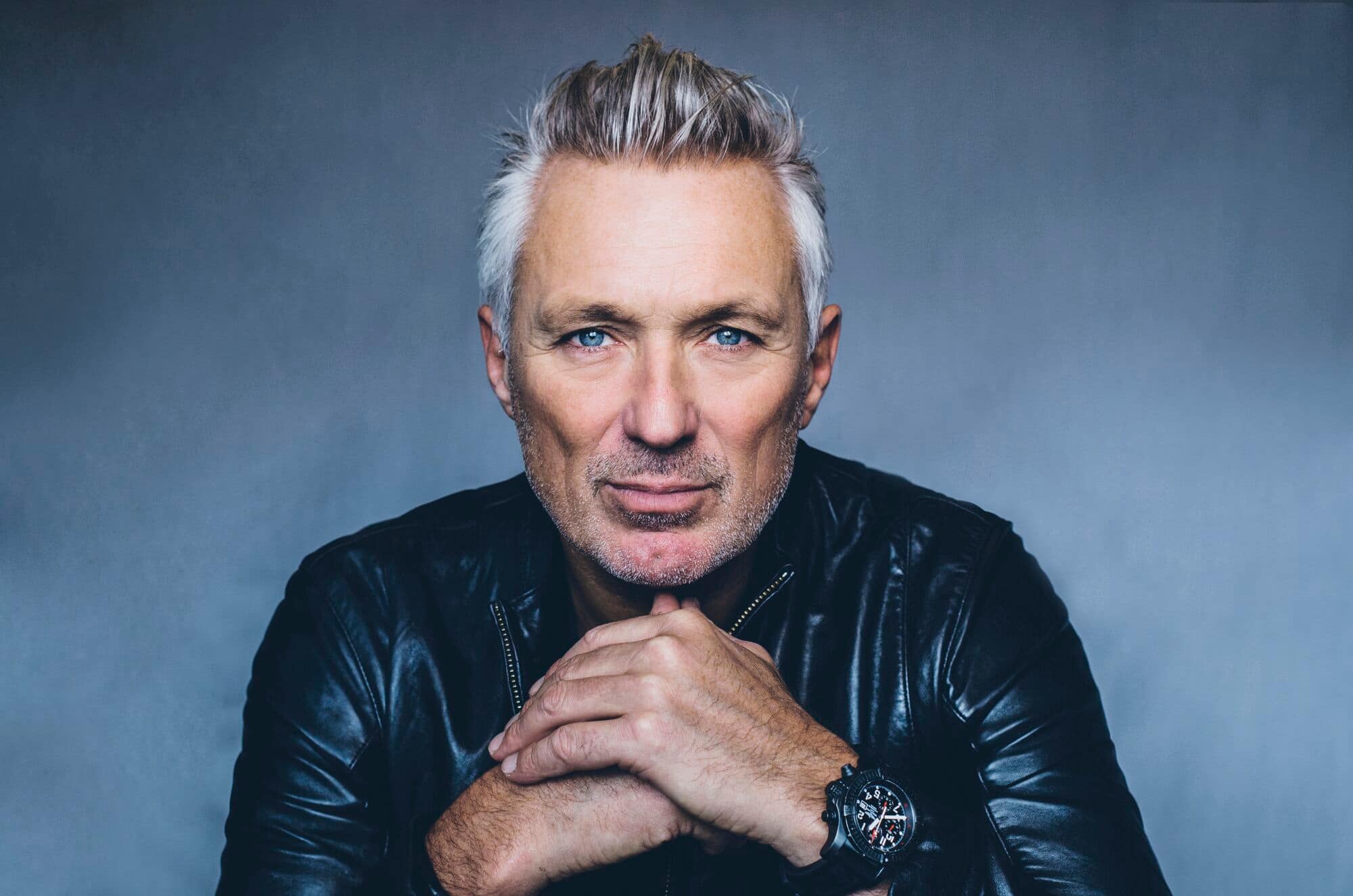 Martin Kemp in front of a grey background.