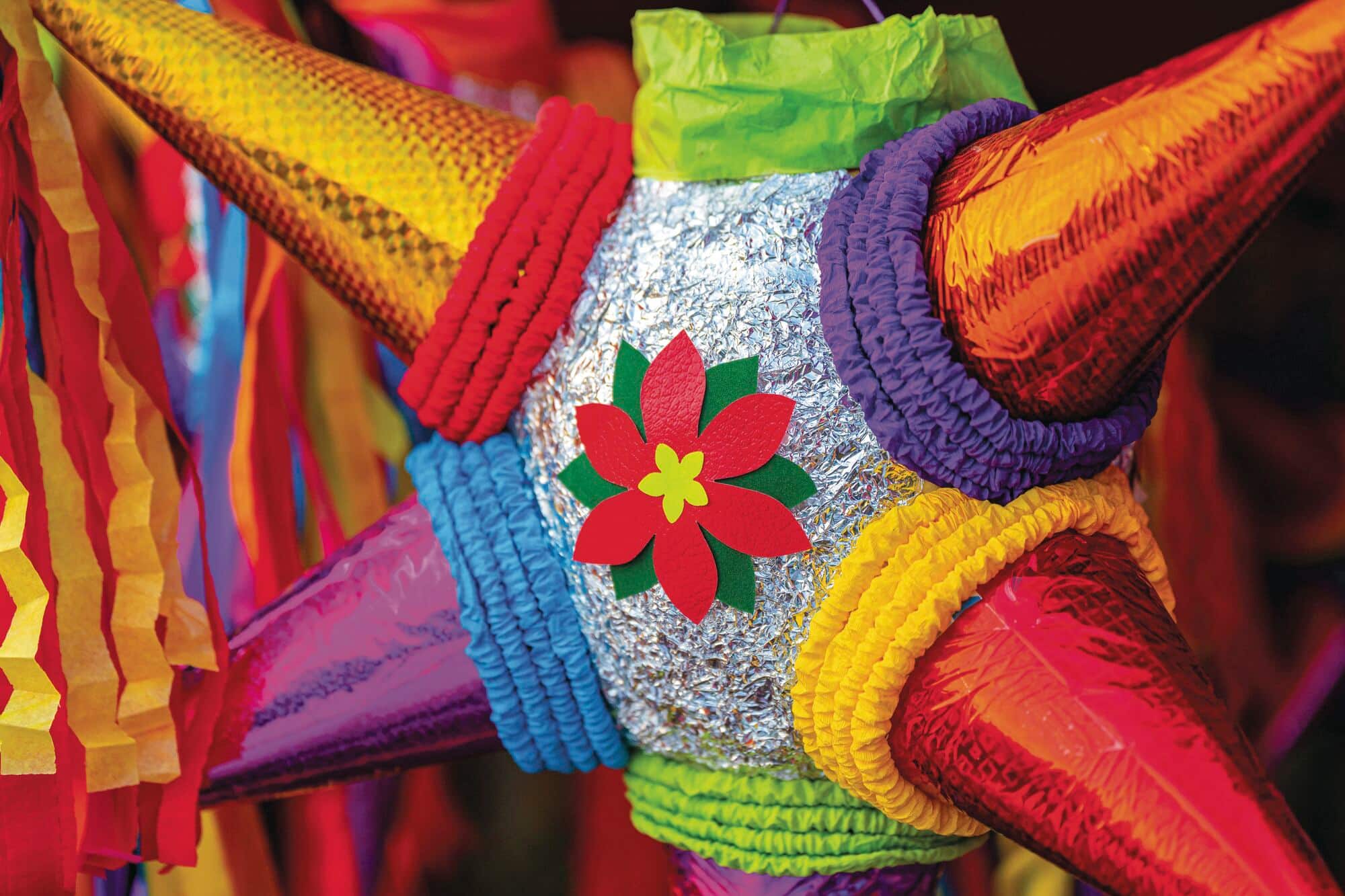 A traditional piñata con nochebuena, bearing a seasonal poinsettia