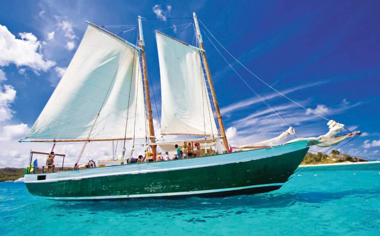 A sailboat on clear blue sea.