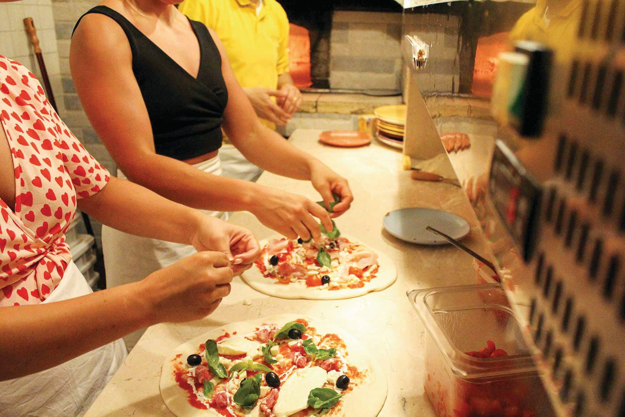 People taking part in a pizza making class.