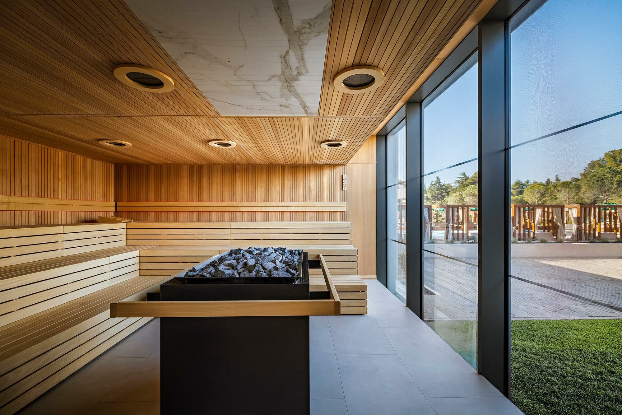 A sauna with floor-to-ceiling windows for a view of the surrounding gardens.