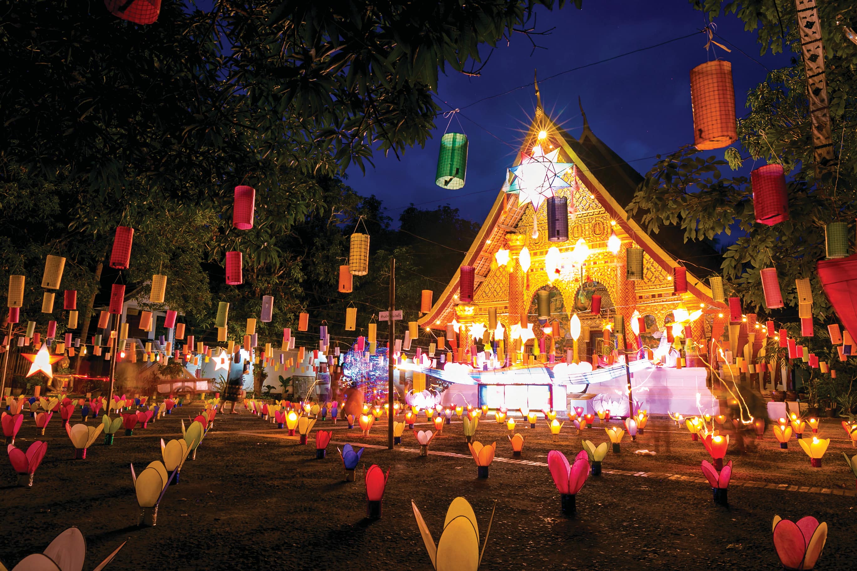 Lanterns and colourful lights decorating a temple at night.