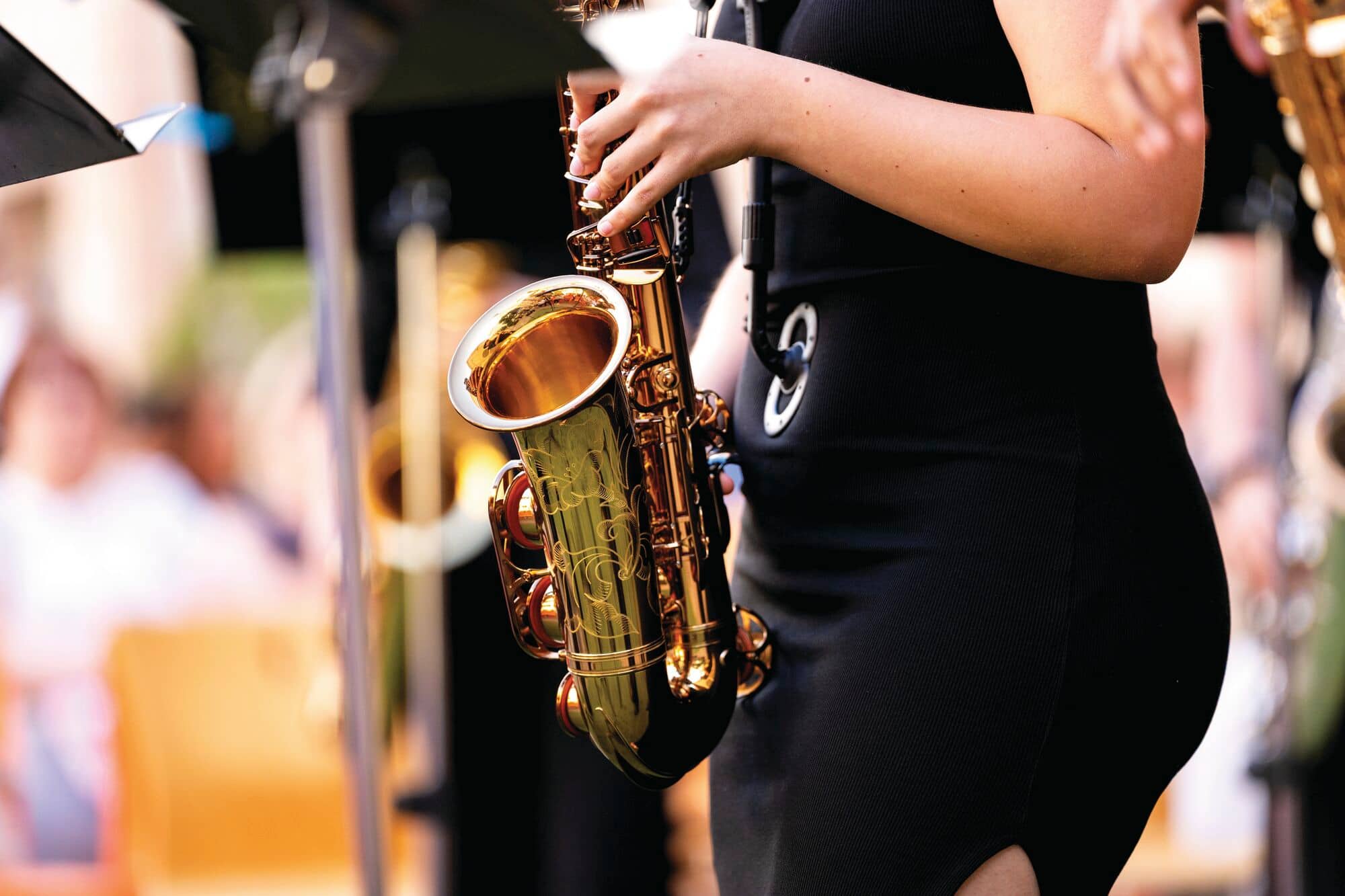 Musician playing a saxophone during an outdoor live music event.