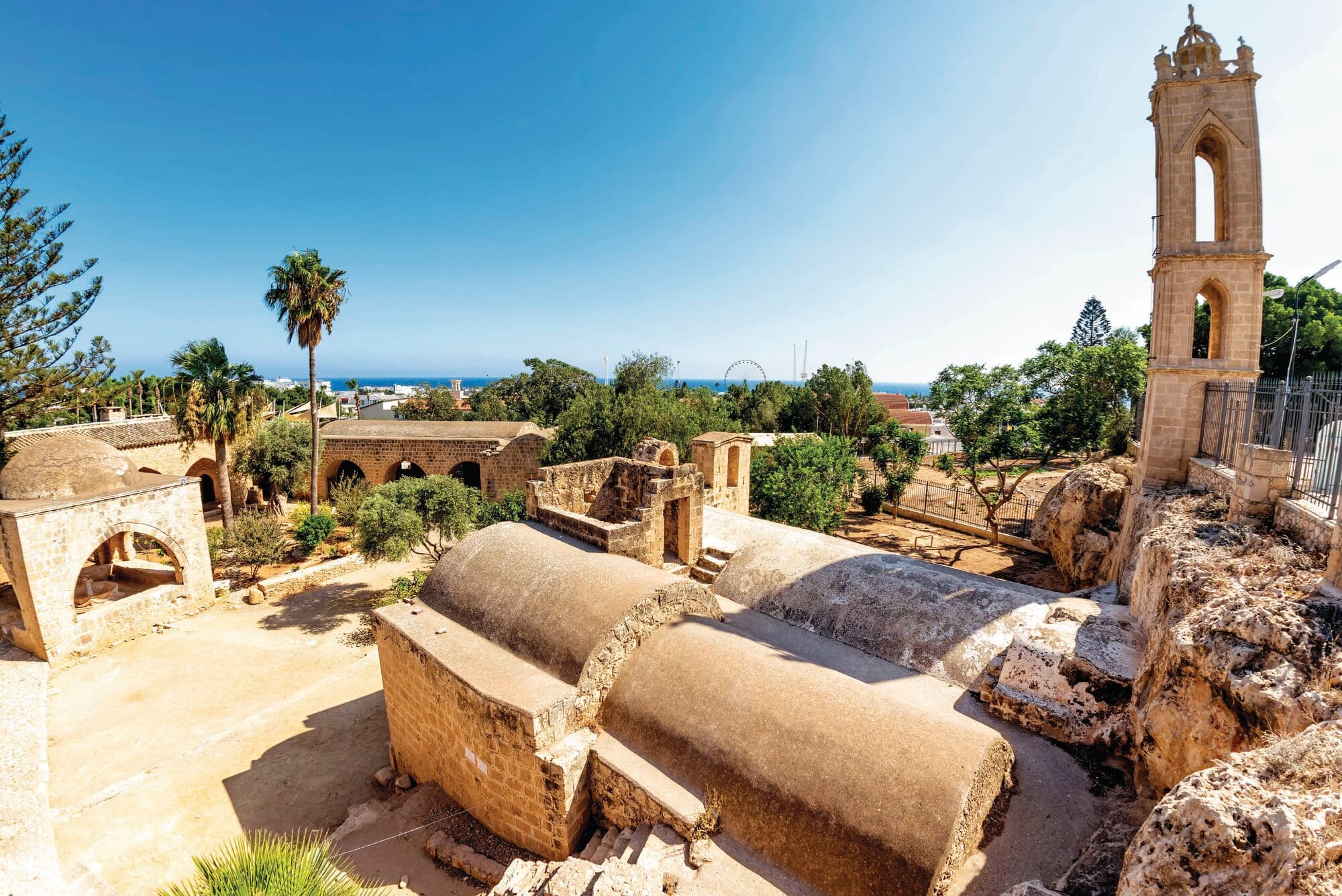 An ancient stone monastery complex under a clear blue sky