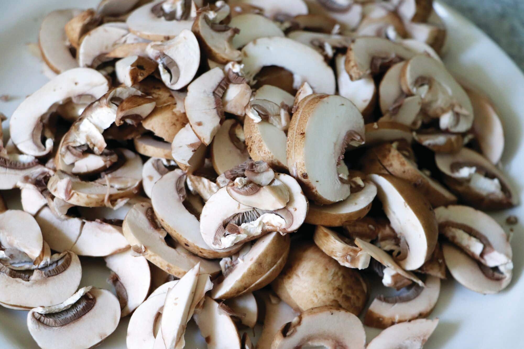  A large pile of thinly sliced brown mushrooms