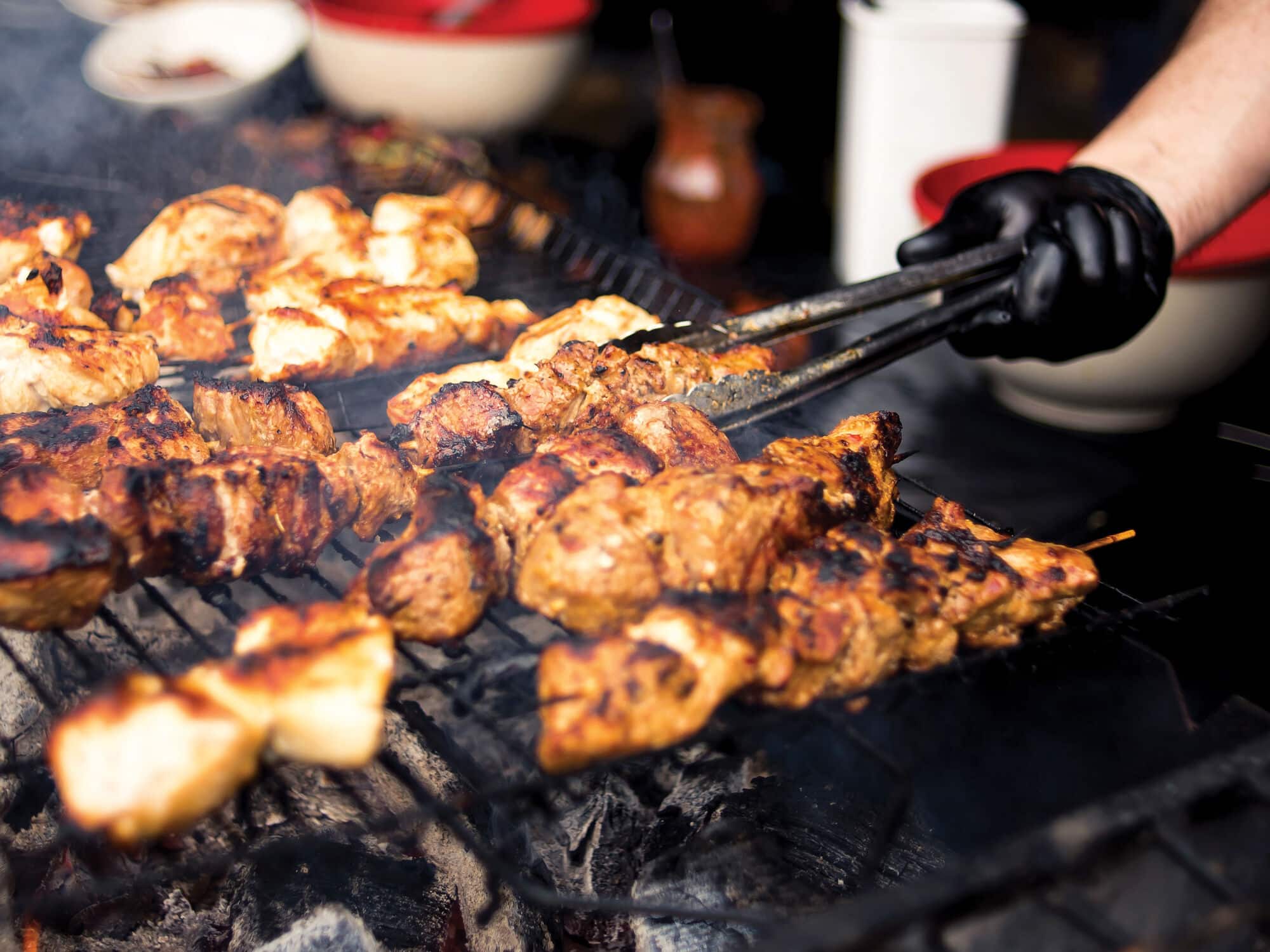Grilled chicken skewers cooking over a charcoal barbecue.