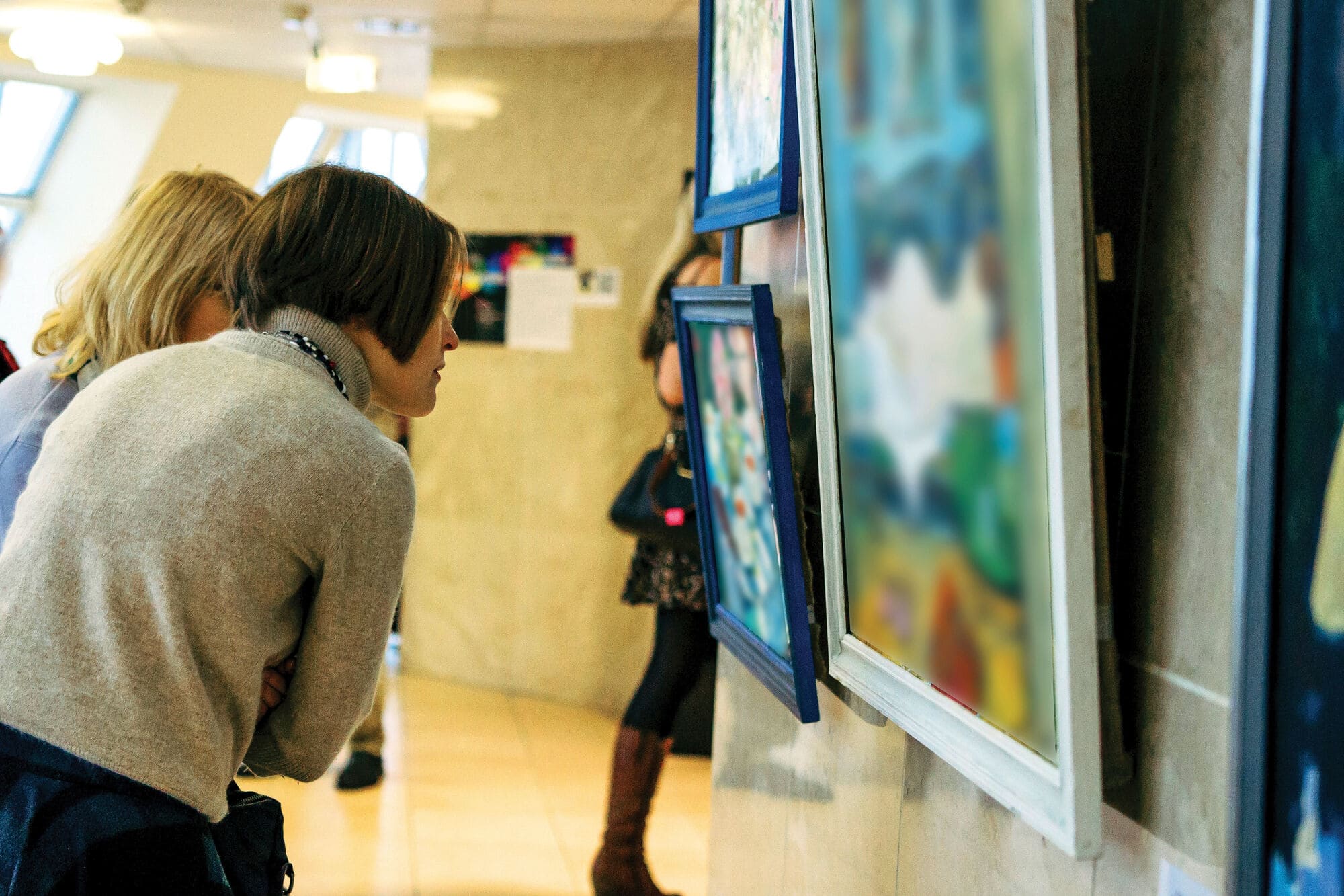 People viewing artwork in an indoor gallery exhibition.