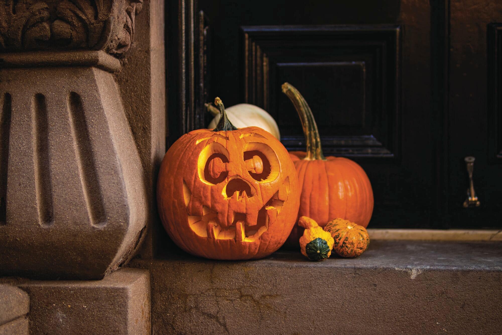 A jack-o-lantern sitting on a stoop in Greenwich Village