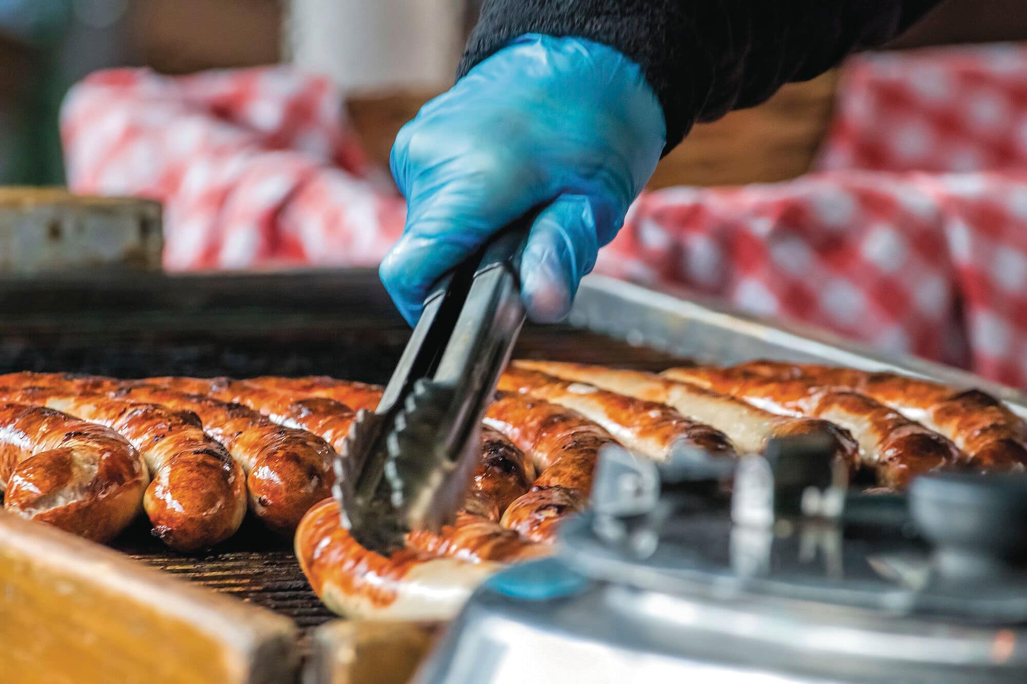 Bratwurst-style sausages being grilled at a food stand