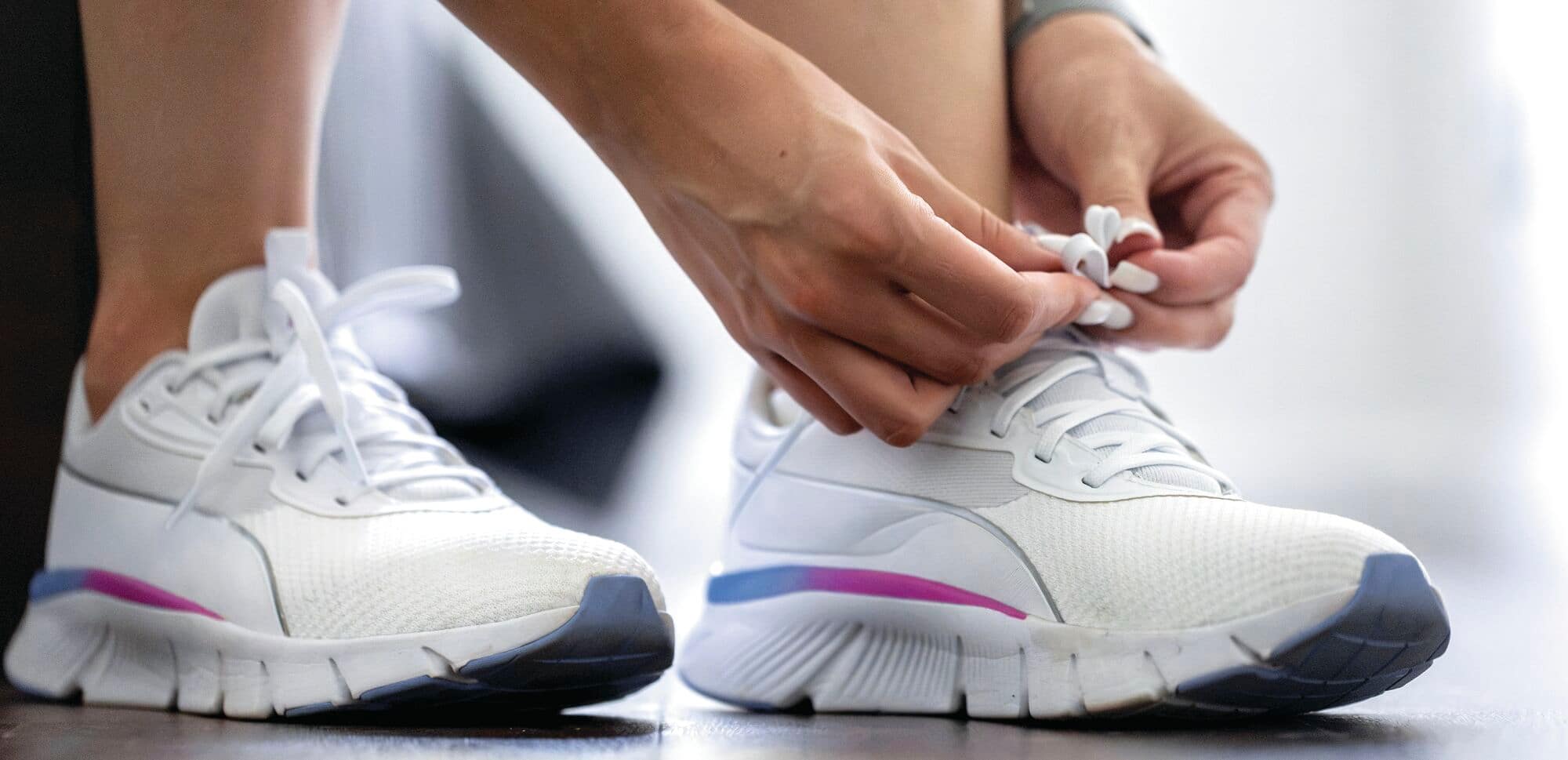 Tying of shoelaces on a pair of trainers