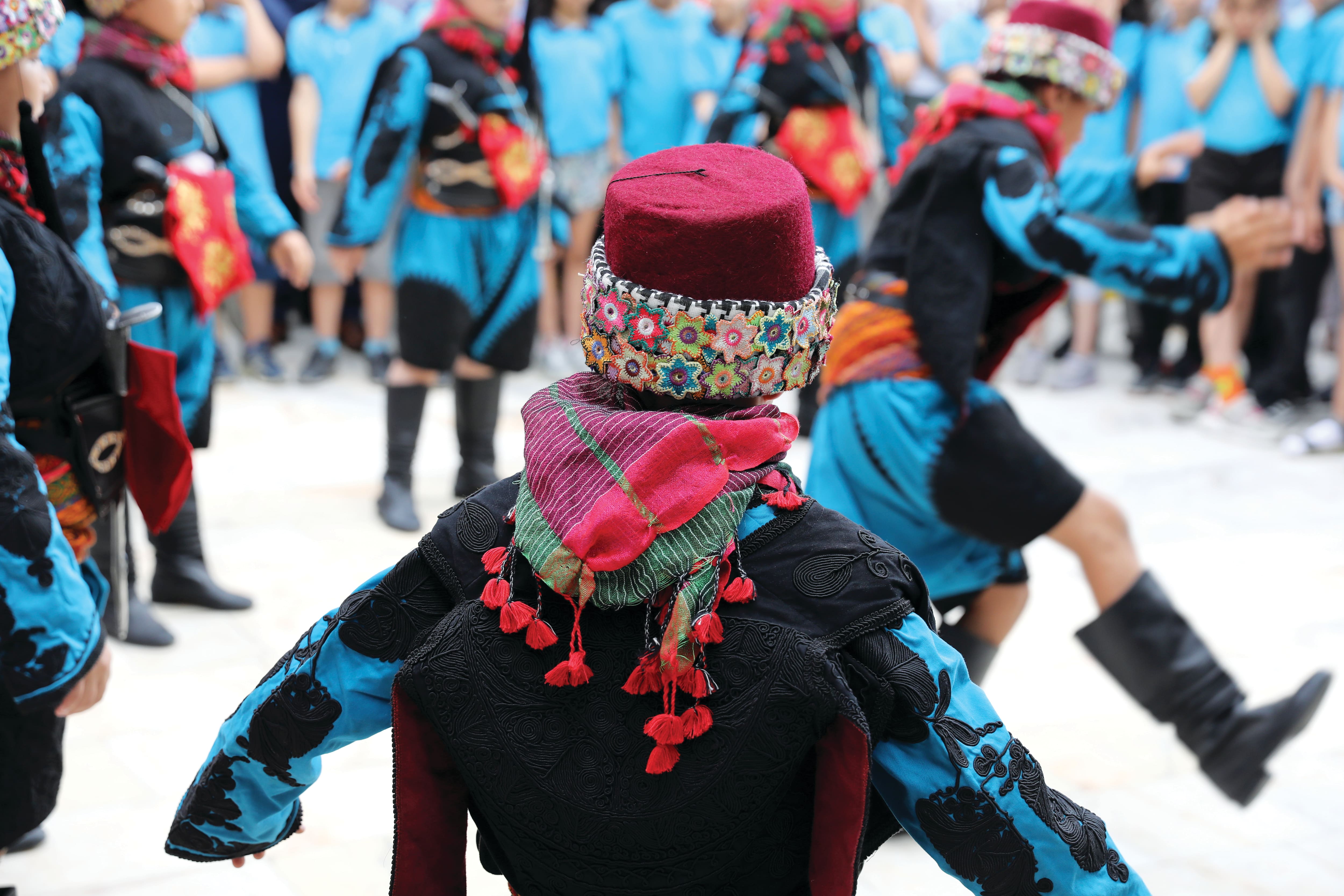 Performers dressed in colourful traditional folk costumes take part in a cultural dance performance. 