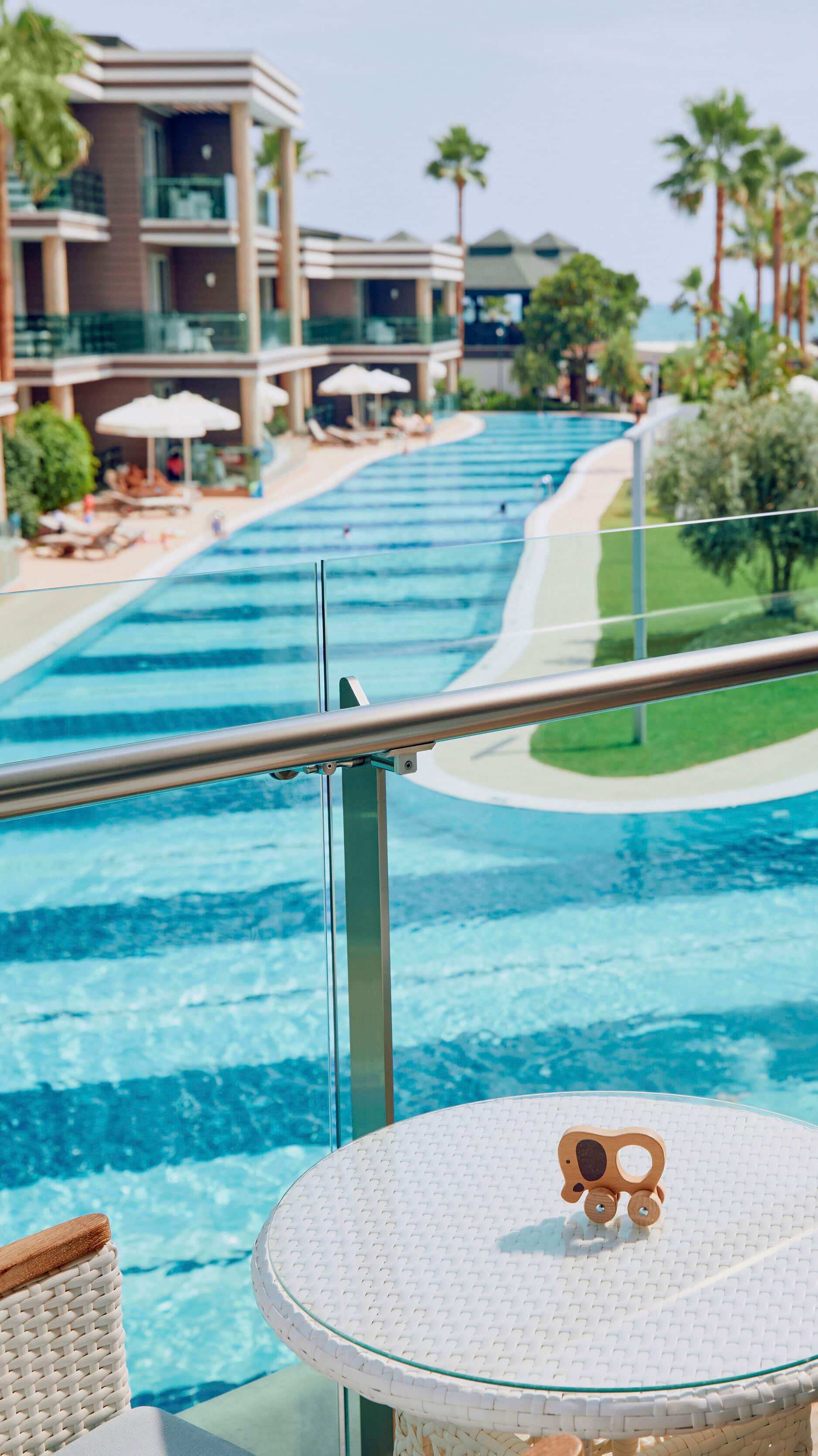 Two chairs on a room balcony that overlooks the pool.