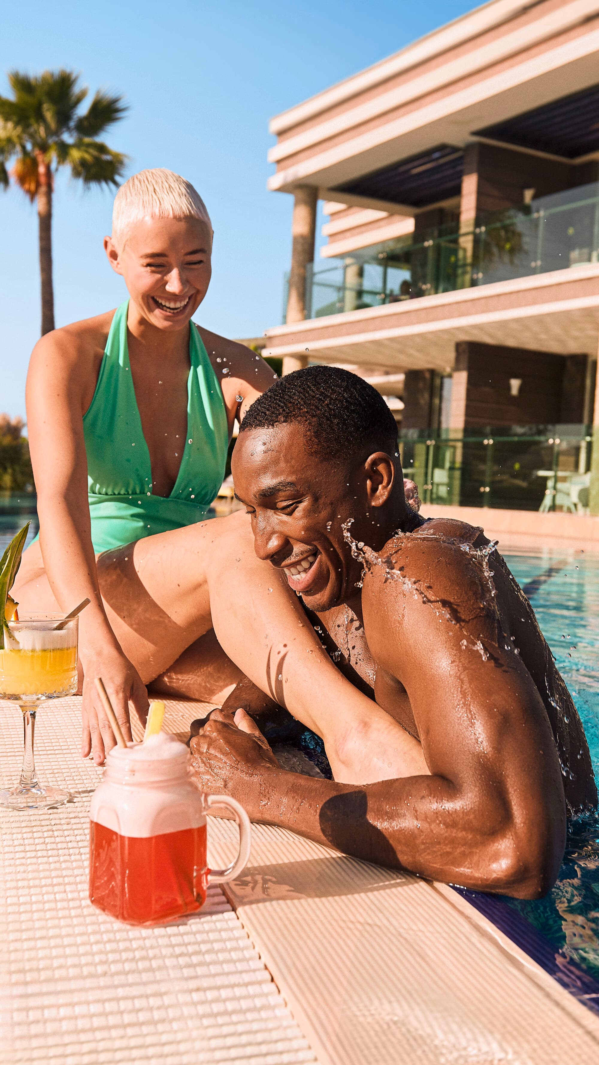 A couple relaxing by the side of a pool.